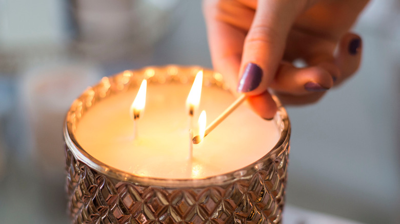 Woman lighting candle with a match