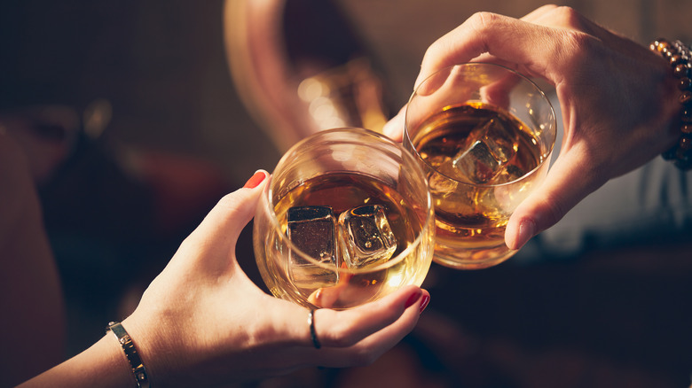 Couple drinking bourbon toasting