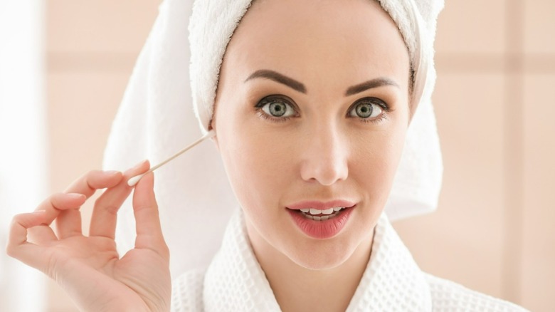 Woman putting Q-tip into ear