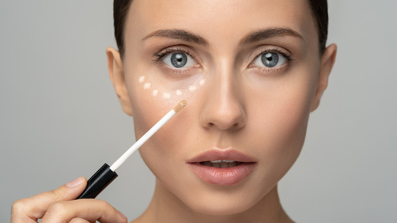 Woman applying concealer