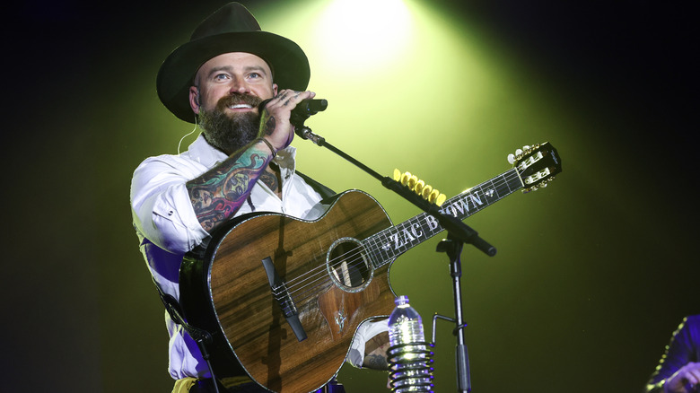 Zac Brown smiling while performing on stage