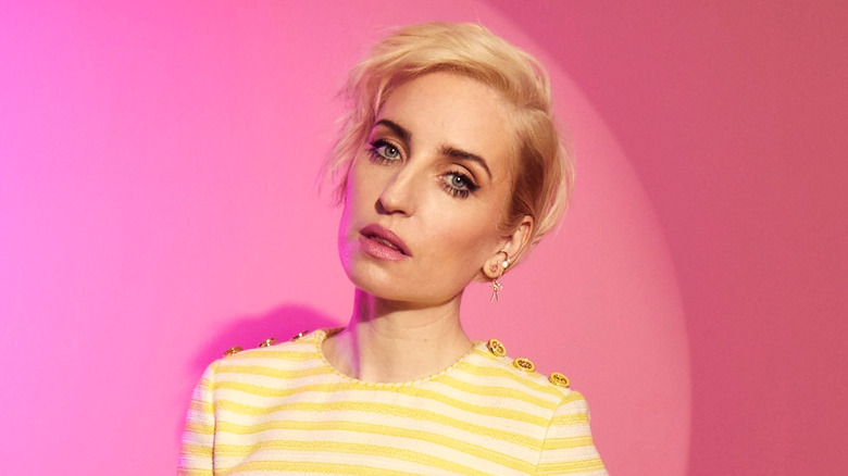 Zoe Lister-Jones posing against pink background