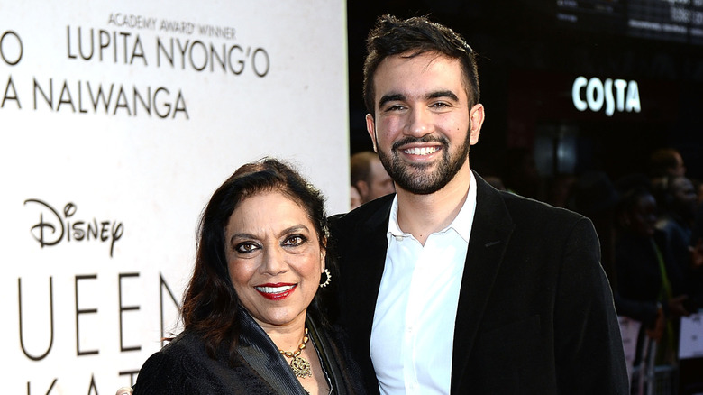 Zohran Mamdani smiling while posing with his arm around Mira Nair