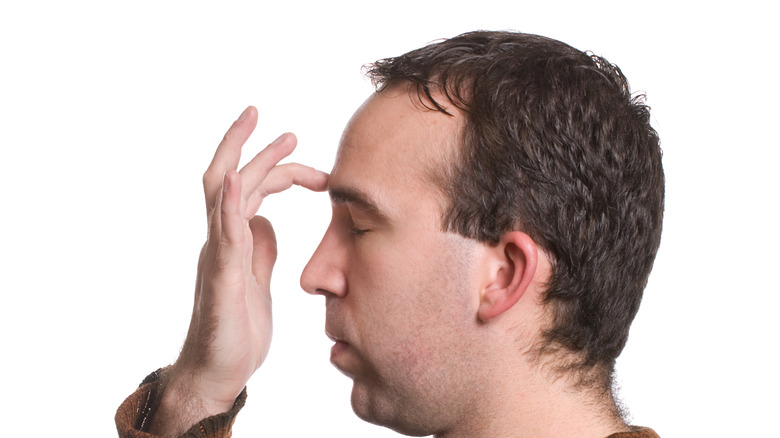 Man tapping finger between brows