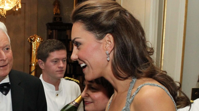 Side profile of Kate Middleton smiling among a group of people