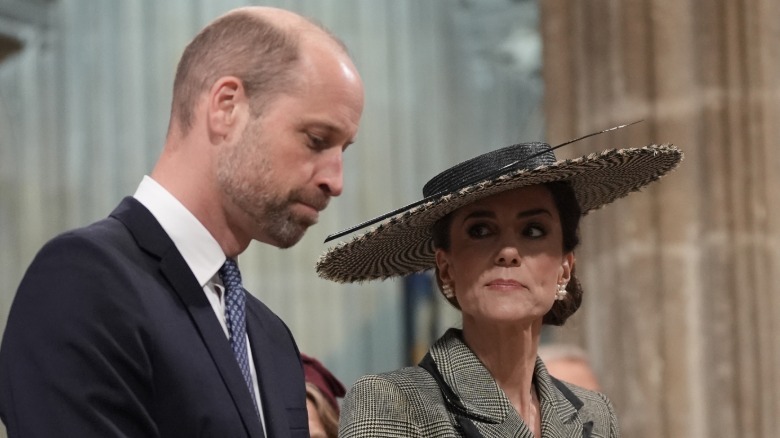 Prince William seemingly grimacing as Kate Middleton appears to stare at him