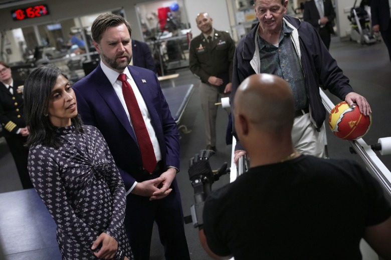 Usha Vance and JD Vance speaking to people in physical therapy center