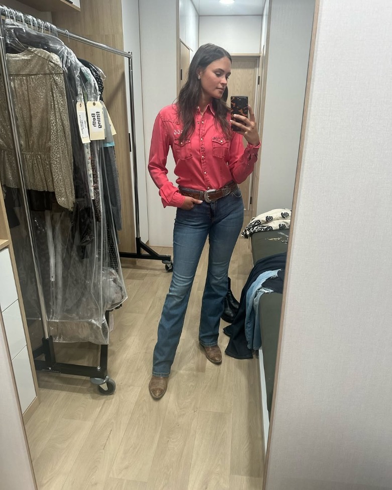 Kathryn Kelly taking a mirror selfie in ranch clothes costume