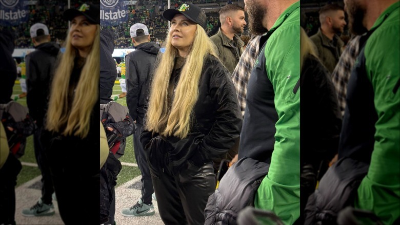 Erik Kirk wearing black leather pants and a black Oregon Ducks hat on the field at a game