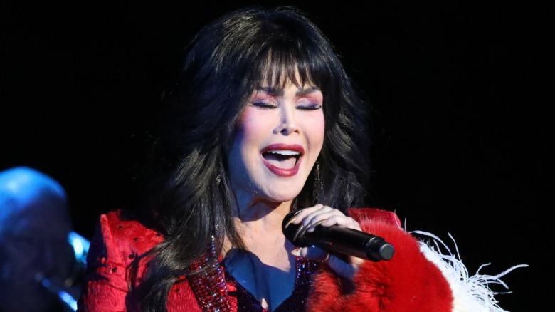 Marie Osmond signing and holding a microphone