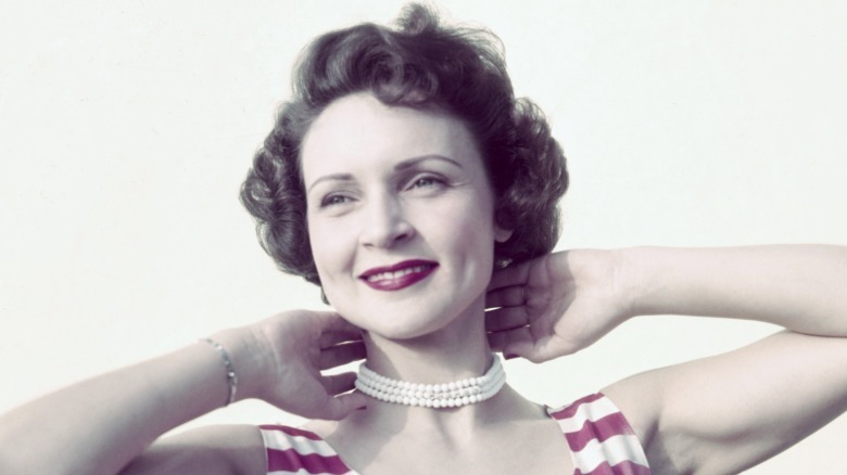 Betty White poses with dark hair and her hands behind her neck for an undated photoshoot