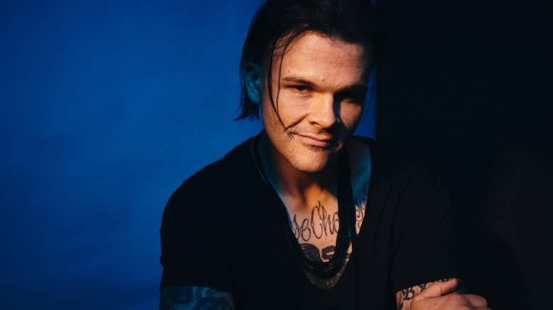 Travis Bacon in 2026 wearing black with a blue background