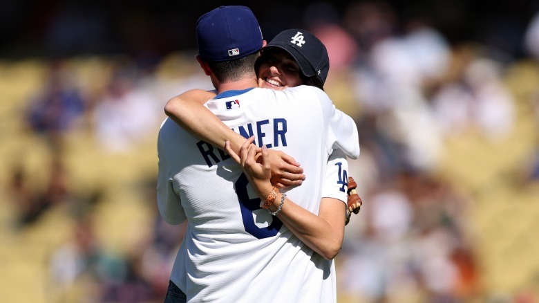 Jake Reiner and Romy Reiner hugging while wearing baseball apparel
