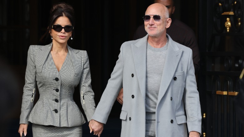 Lauren Sánchez and Jeff Bezos walk hand in hand
