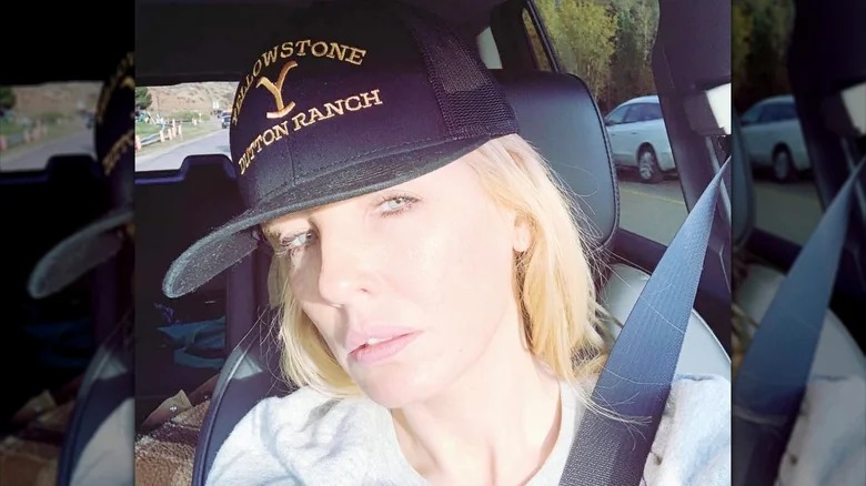 Kelly Reilly sitting in a car and wearing a 'Yellowstone' cap