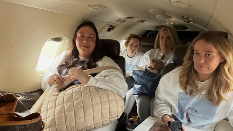 Tricia McLaughlin sitting on a cramped private jet with three other women.