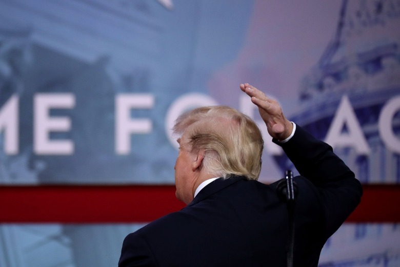 Donald Trump gesturing to the bald spot on the back of his head