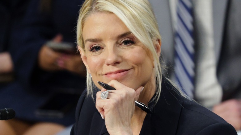 Pam Bondi smiling with her hand on her chin