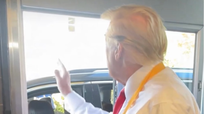 Donald Trump waves to a car