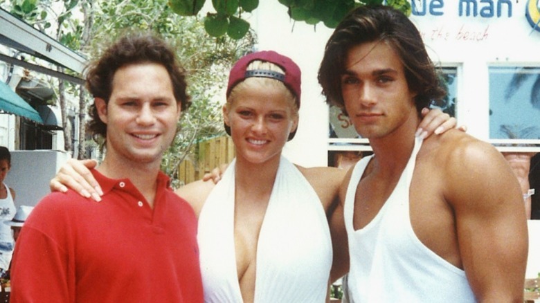 Anna Nicole Smith posing between two brunette men