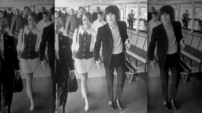 Pattie Boyd and George Harrison walking hand in hand at the airport before their Bahamas honeymoon