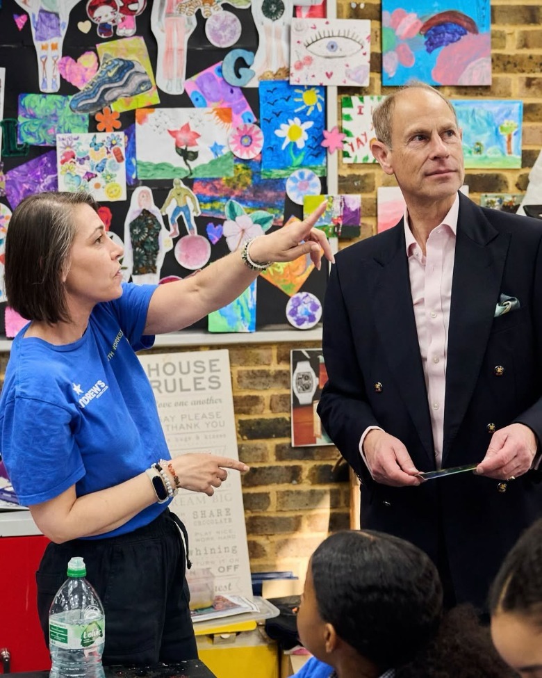 A woman pointing as she stands next to Prince Edward