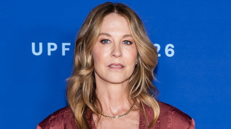 Jenna Elfman in front of blue backdrop looking forward