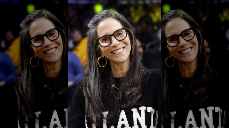 Jami Gertz in an Atlanta sweat shirt with minimal makeup and black glasses frames from January 2025