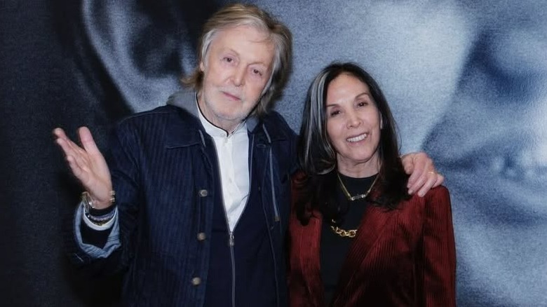 Paul McCartney with his arm around Olivia Harrison
