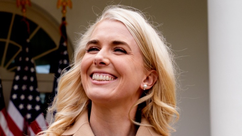Natalie Harp smiling in front of American flags
