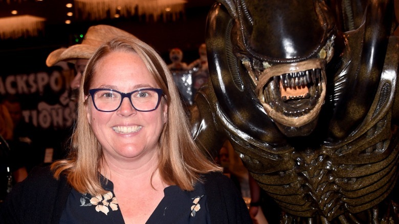 Carrie Henn smiling with a xenomorph figurerine