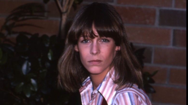 Jamie Lee Curtis with long hair wearing a striped shirt