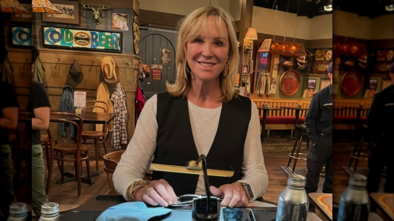 Joanna Kerns smiles in a white shirt and black vest